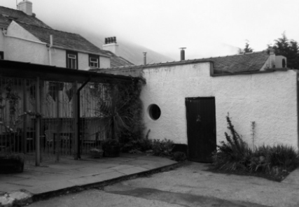 The doorway into the brewery yard at the rear of the Wasdale Head Inn with a misty Sca Fell in the distance.