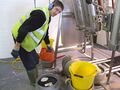 Lawrence Wilson washes the fob off the filled cask using a watering can